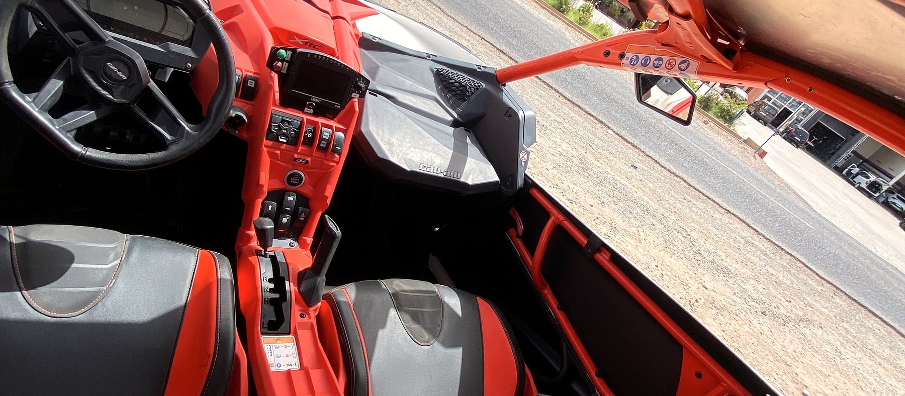 Poste de pilotage d'un Can-Am Maverick X3 : volant, harnais et sièges baquets