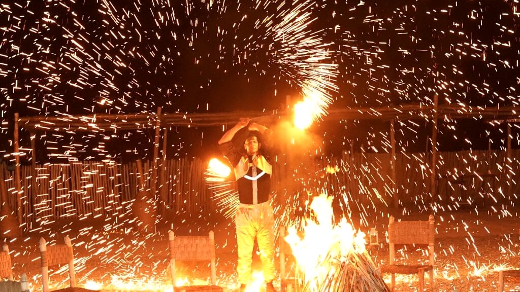 Artiste de feu en pleine performance dans la nuit, gerbes d'étincelles