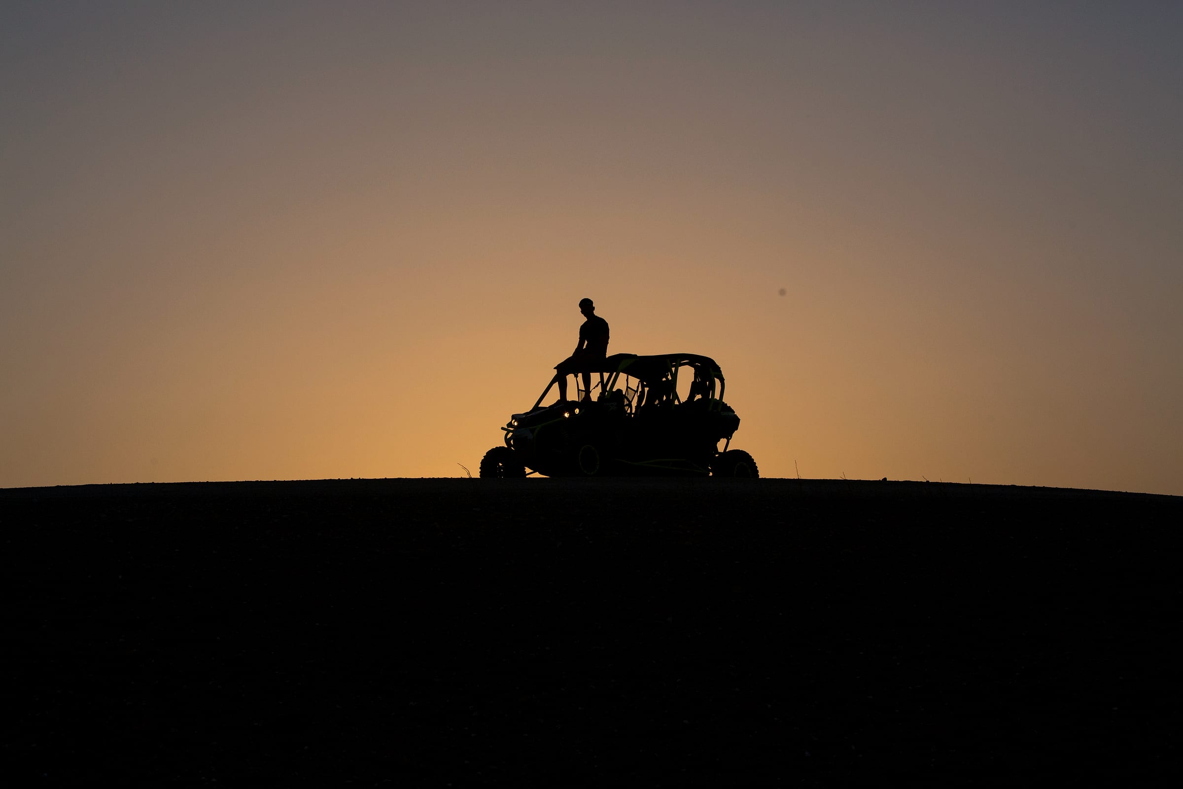 Buggy seul en silhouette sur la ligne de crête, ciel de fin de journée
