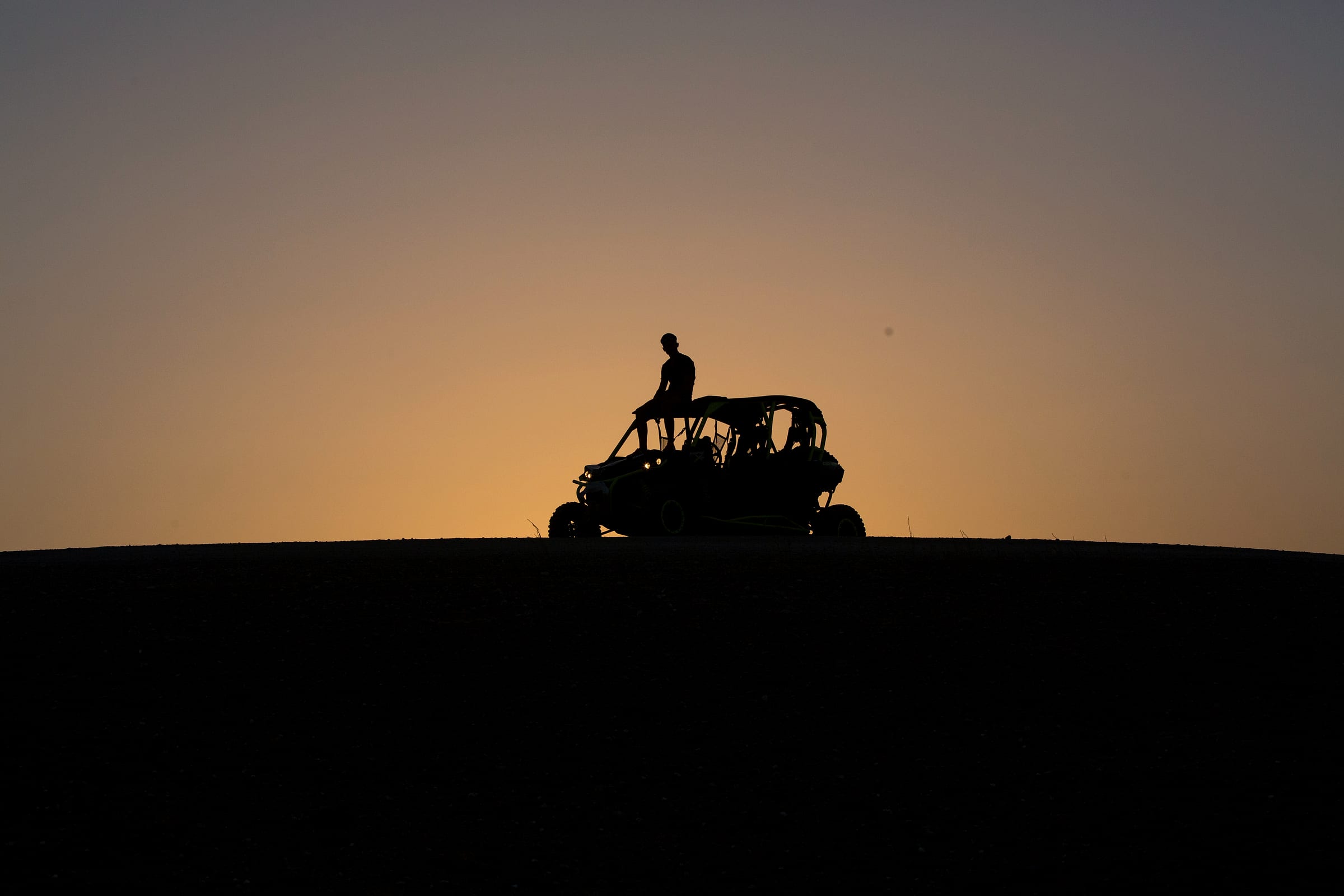 Buggy seul en silhouette sur la ligne de crête, ciel de fin de journée