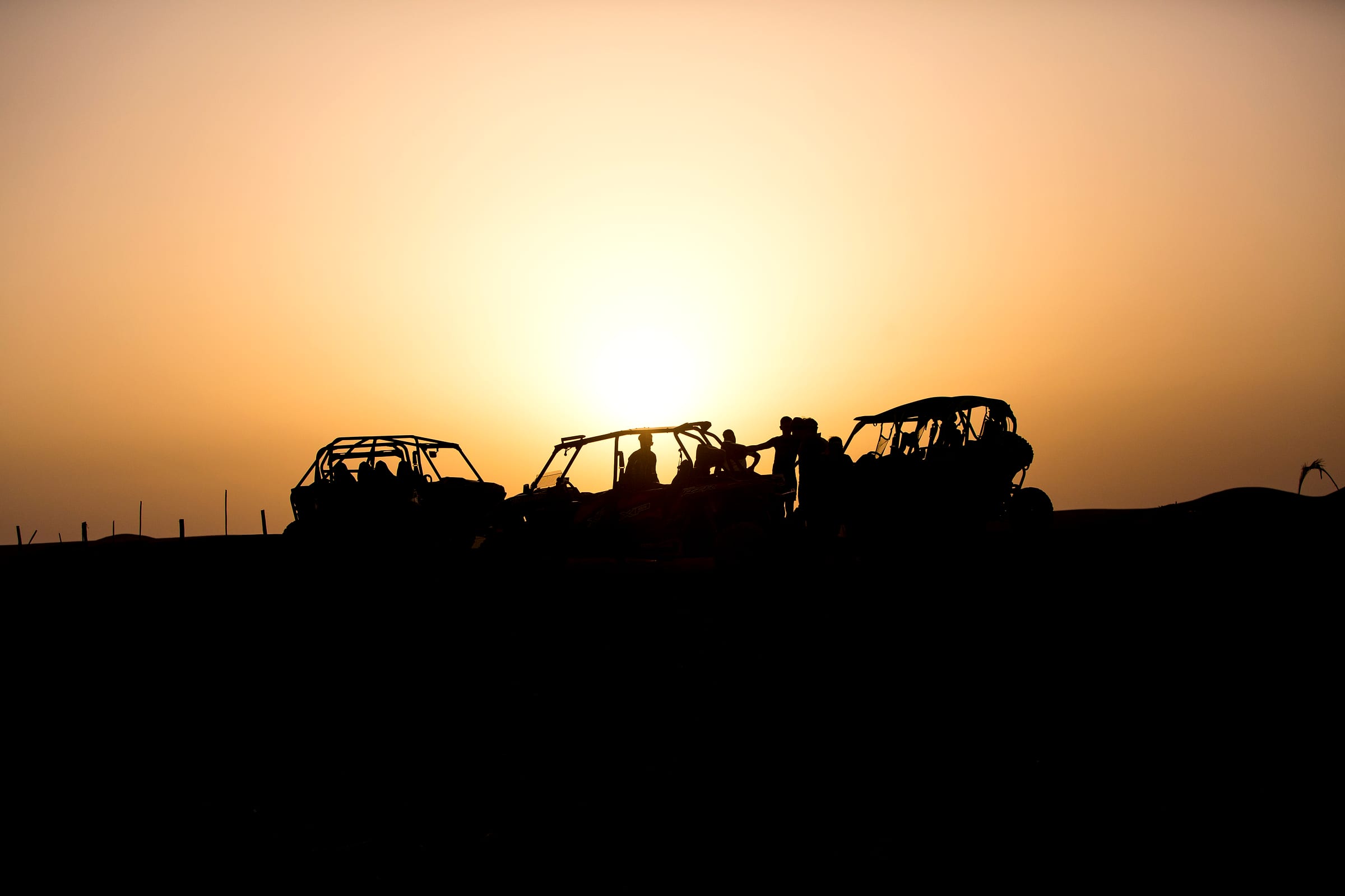 Buggys rassemblés face au soleil couchant sur le plateau rocheux