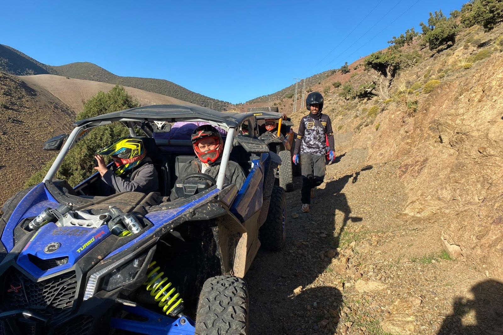Buggys Can-Am à l'arrêt sur une crête rocheuse, montagnes en fond