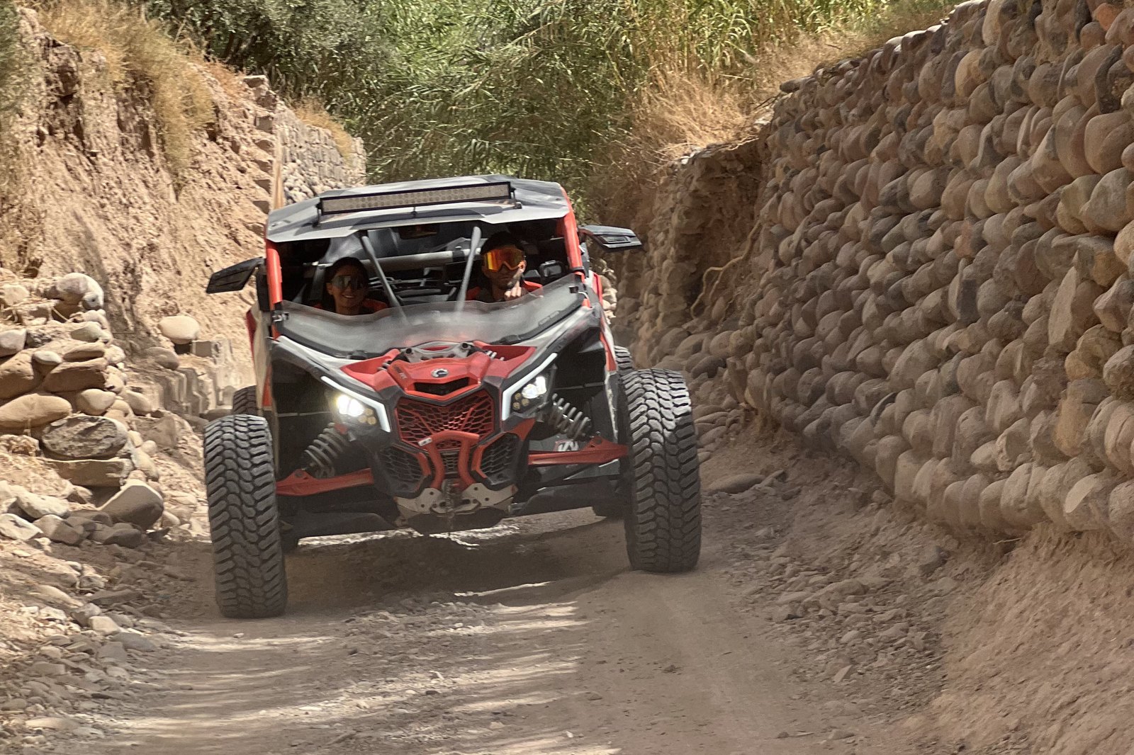 Buggy Can-Am soulevant la poussière sur une piste de montagne